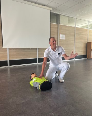Ein Arzt demonstriert Erste Hilfe an einer Übungspuppe.